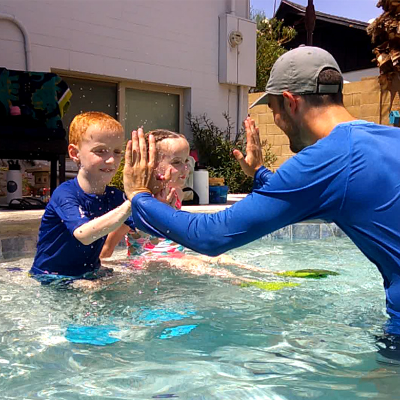 Swim Instructor Giving High Five to Kids in Pool