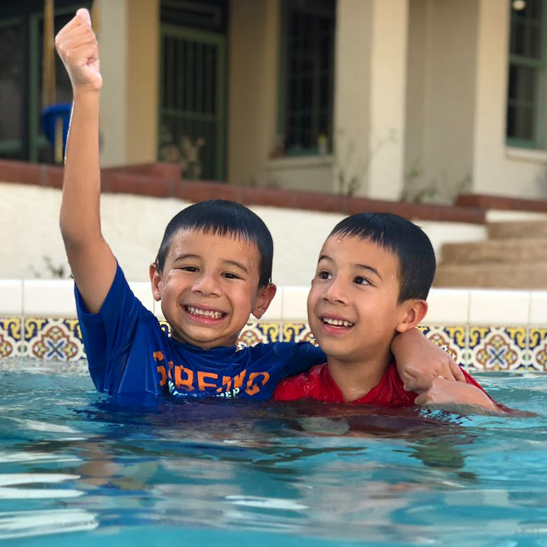 Two boys celebrating their swim stroke development