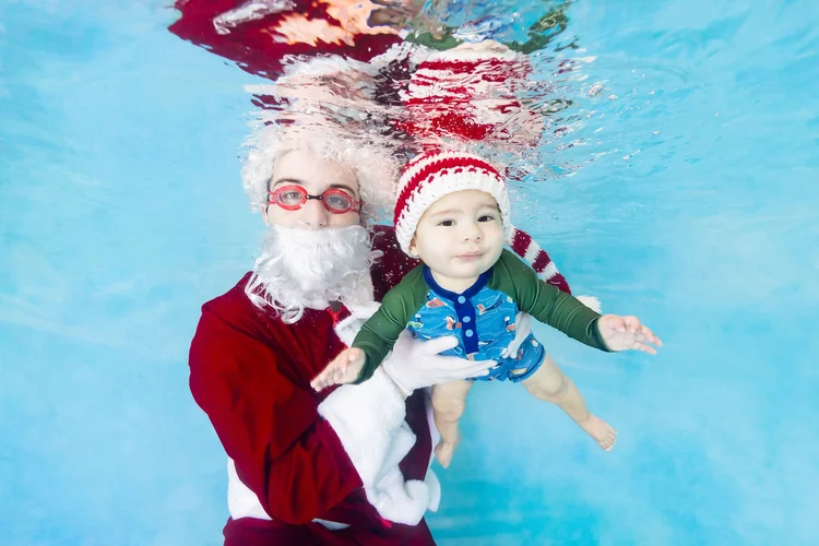 Baby swimming underwater with Santa during a Kidtastics holiday photo session in Scottsdale.